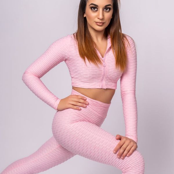 A person performing a gentle stretching yoga pose, glowing with pink energy.